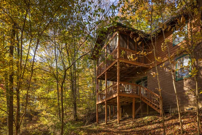 Screened porch overlooking wooded hillside at Chickadee Cabin
