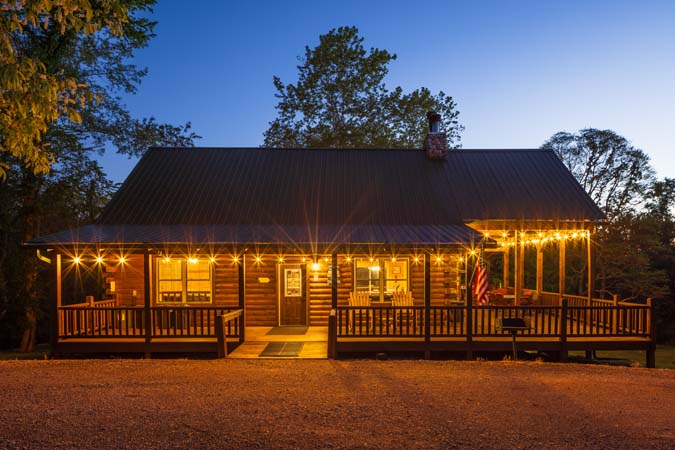 Green Acres Lodge illuminated at dusk surrounded by trees