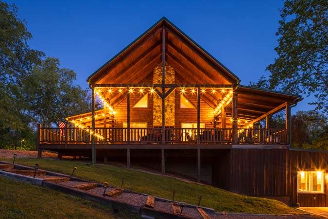 Green Acres Lodge exterior lighting and wooded setting at dusk