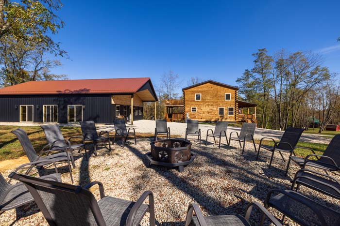 Fire pit with circle of chairs between the barn and lodge