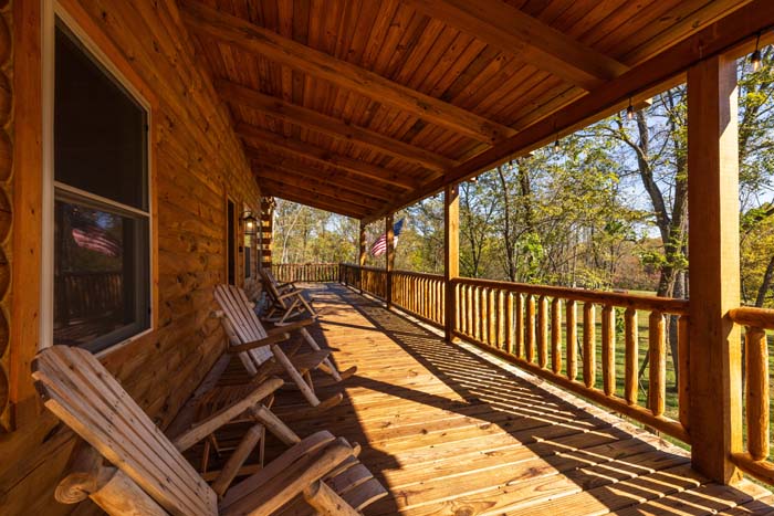 Covered porch with wooden rocking chairs and flag