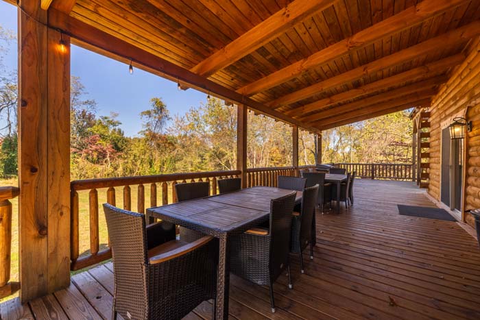 Covered deck dining with string lights and field views