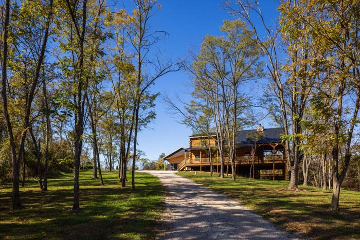 Tree-lined gravel driveway leading to Highland Lodge