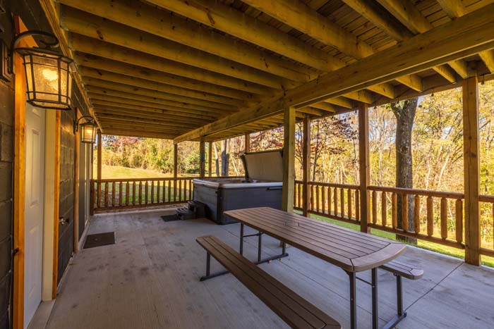Lower covered patio with hot tub and picnic table