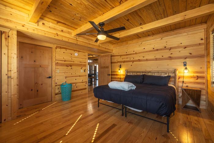 Bedroom with king log bed and ceiling fan