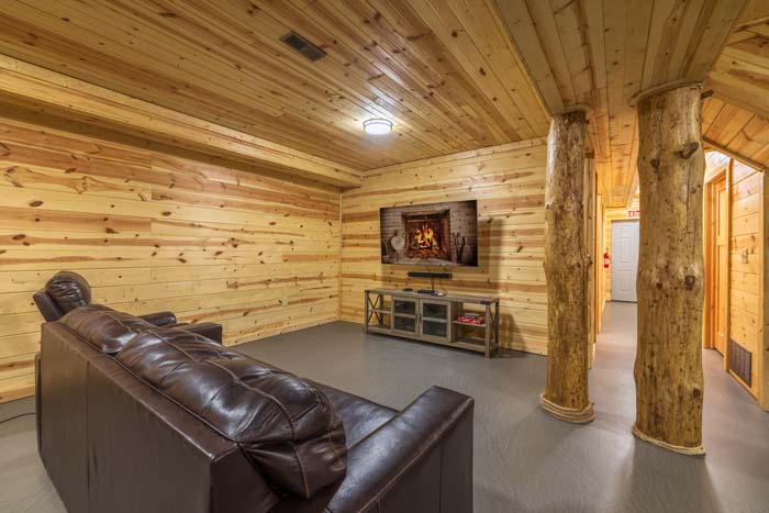 Lower rec room with leather sofa and wall-mounted TV