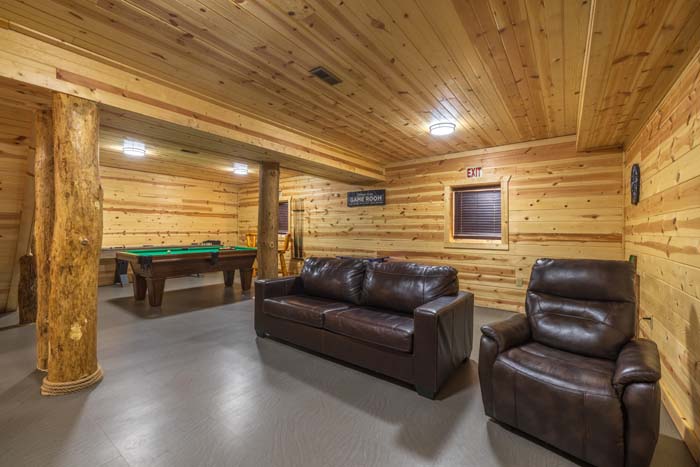 Lower rec room with leather seating and pool table