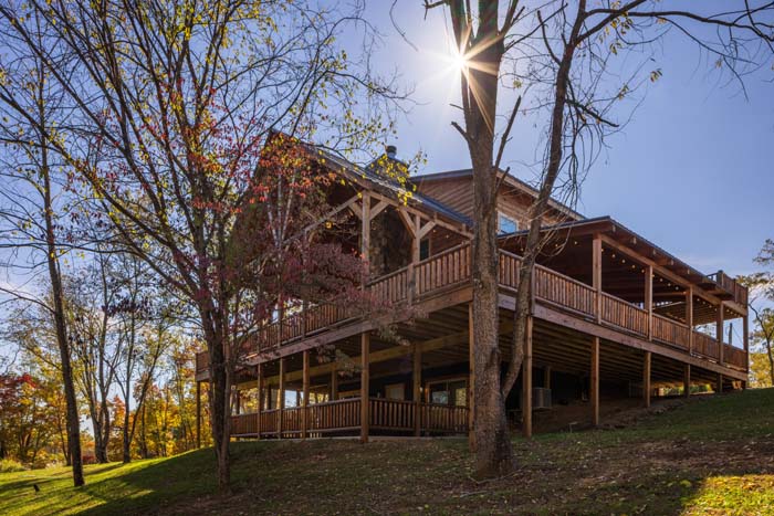 Highland Lodge log exterior with sun through the trees