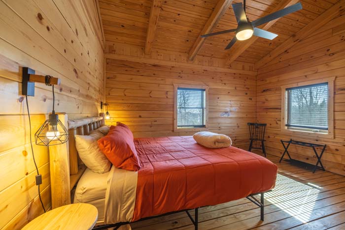 Bedroom with orange bedding and log bed