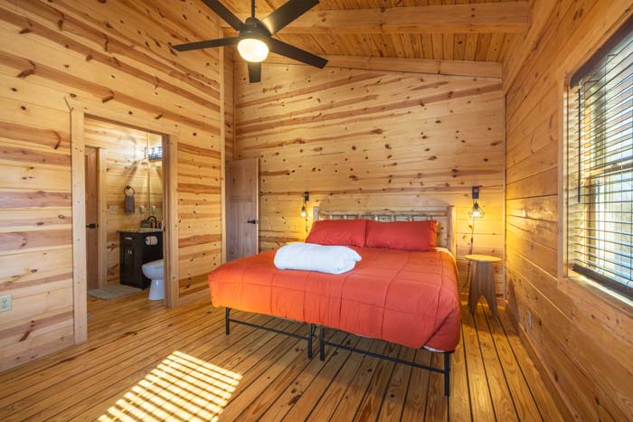 Bedroom with orange bedding and ensuite bath