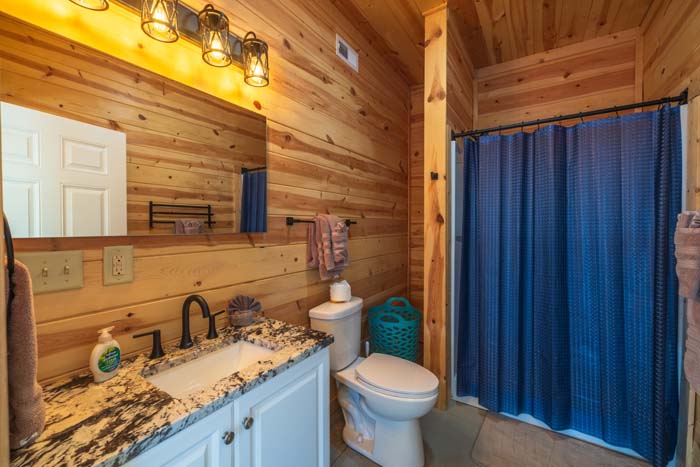Bathroom with white granite vanity and blue shower curtain