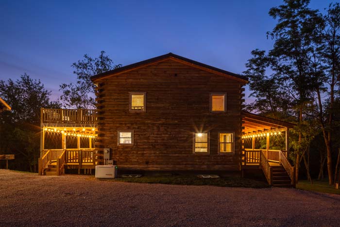 Highland Lodge log cabin illuminated at dusk