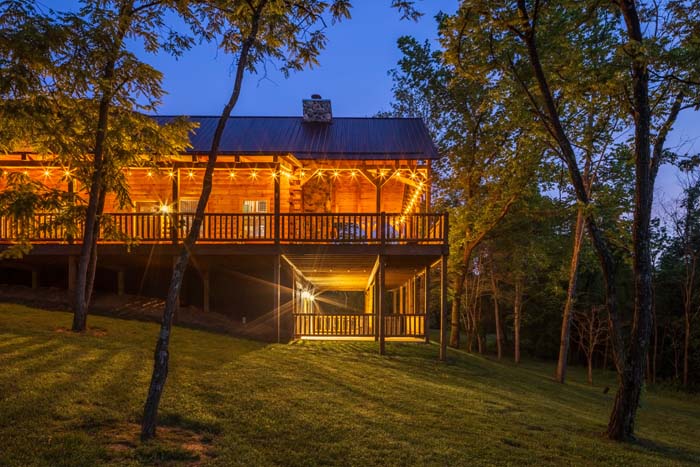 Highland Lodge at dusk with wraparound deck glowing