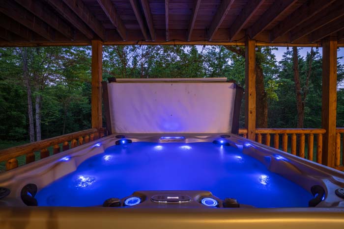 Hot tub lit blue at dusk with picnic table