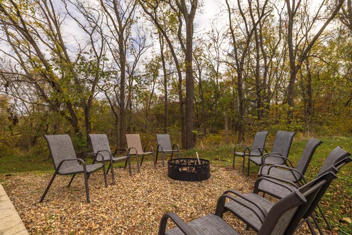 Fire pit with circle of chairs in the woods
