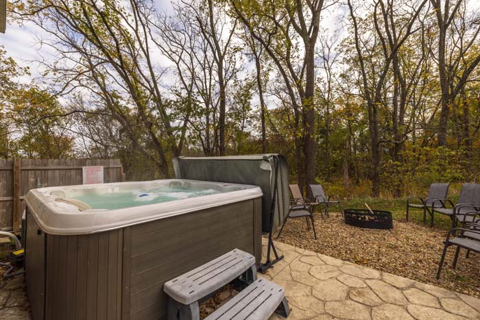 Hot tub with fire pit and seating beyond