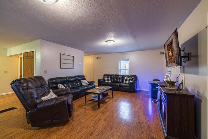 Living room with black leather sofas and TV