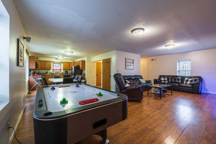 Open game area with air-hockey table beside the kitchen