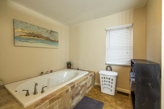 Jacuzzi soaking tub with window and wall art