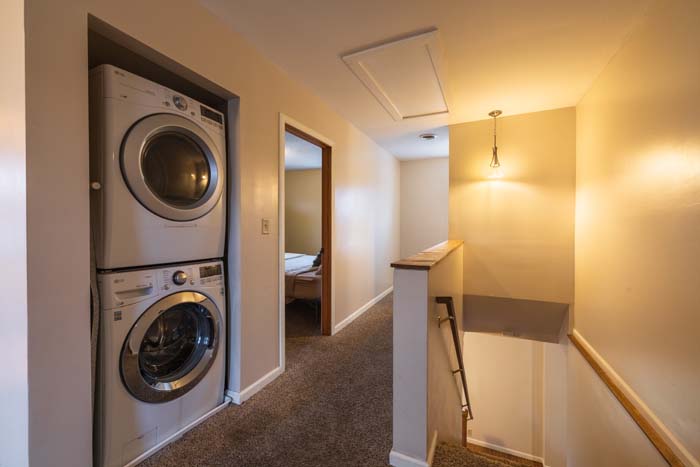 Upstairs hallway with stacked washer and dryer
