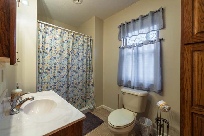 Bathroom with floral shower curtain and vanity