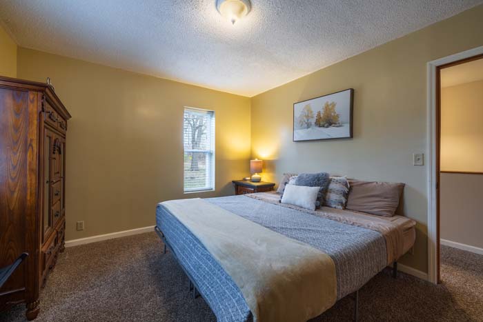 Bedroom with king bed and armoire
