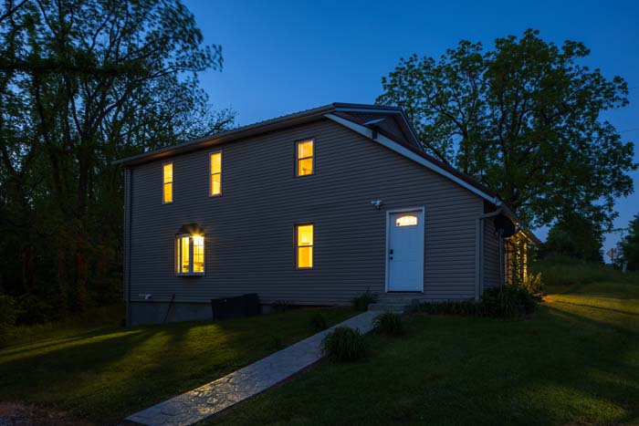 Rear exterior of Hiker's Hideout lit at dusk