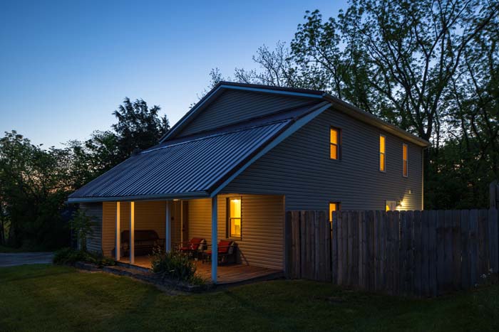 Exterior at dusk with covered porch lit