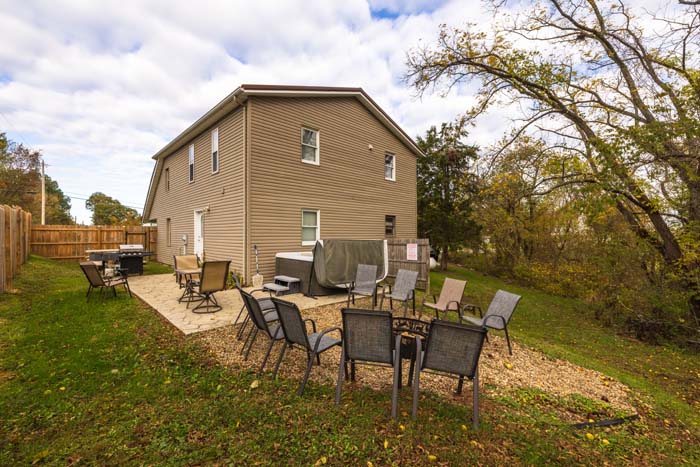 Backyard with fire pit, patio, grill, and hot tub at Hiker's Hideout