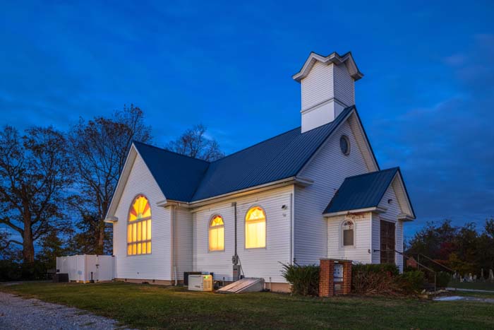 Front view of Dragonfly Inn with landscaped entry and white siding