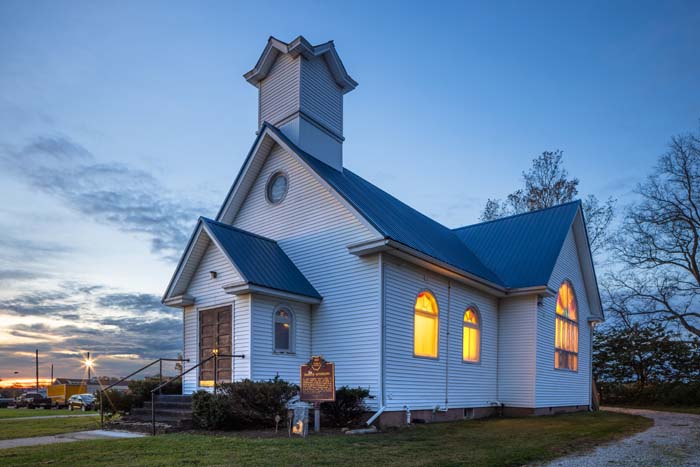 Great room showcasing restored beams and modern furnishings