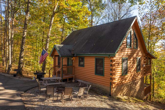 Outdoor hot tub surrounded by trees at Mockingbird Cabin