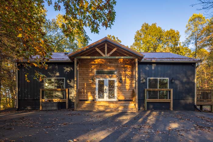 Peach Tree Lodge exterior with wood-accented covered entry and black board-and-batten siding