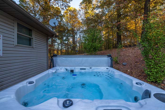 Private hot tub on the deck surrounded by woods at Peach Tree Lodge