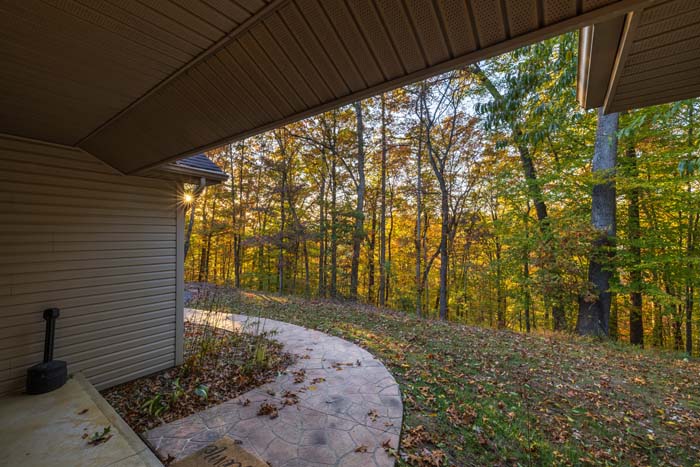 Stamped-concrete walkway along the lodge with forest views