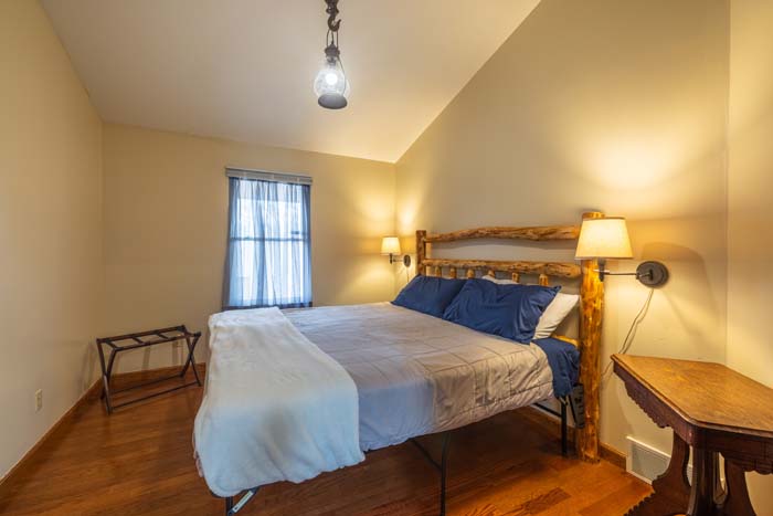 Bedroom with log bed and hardwood floors at Peach Tree Lodge