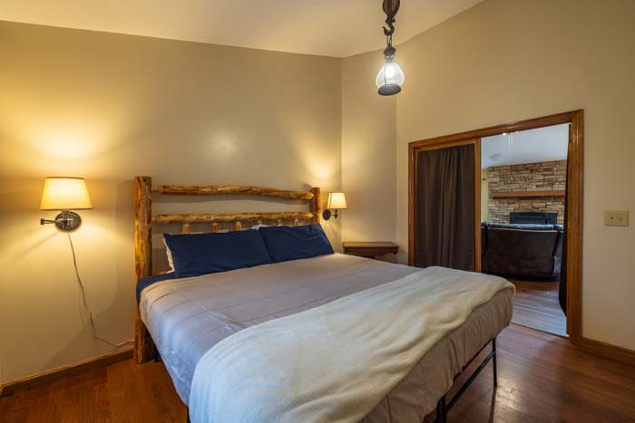 King bedroom with log bed and connecting room