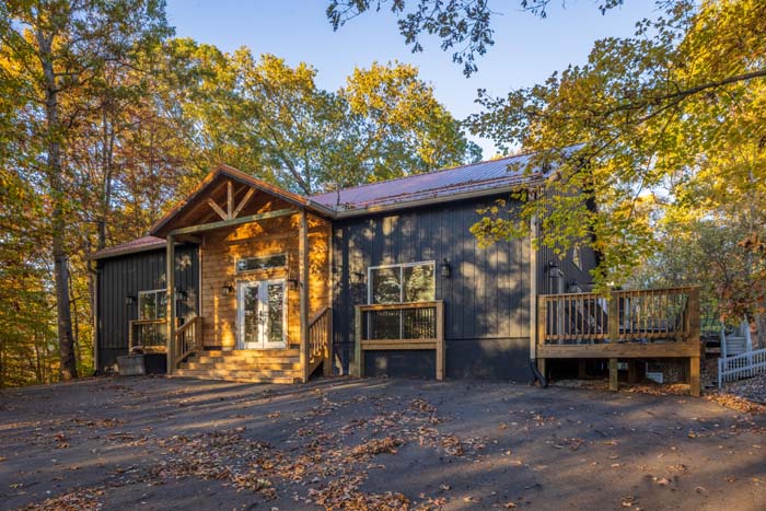 Front exterior of Peach Tree Lodge with covered porch and deck in fall