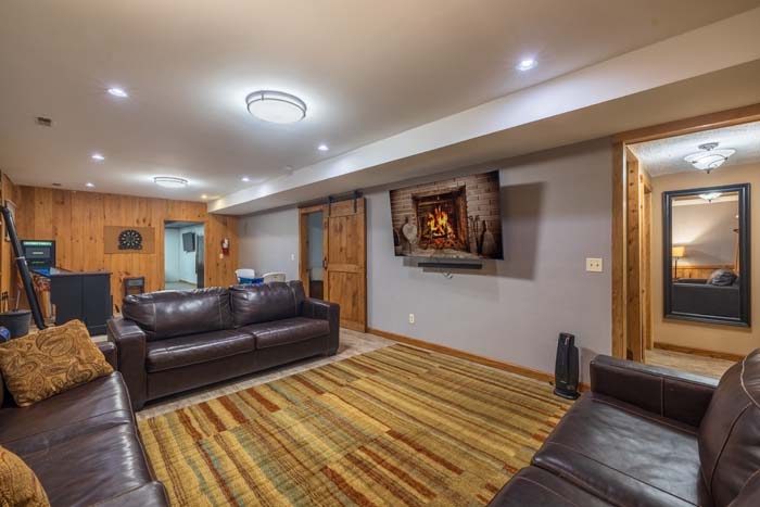 Lower-level den with leather seating and mounted TV