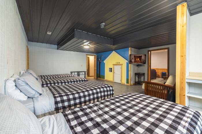 Bunk room with checkered bedding and playhouse mural