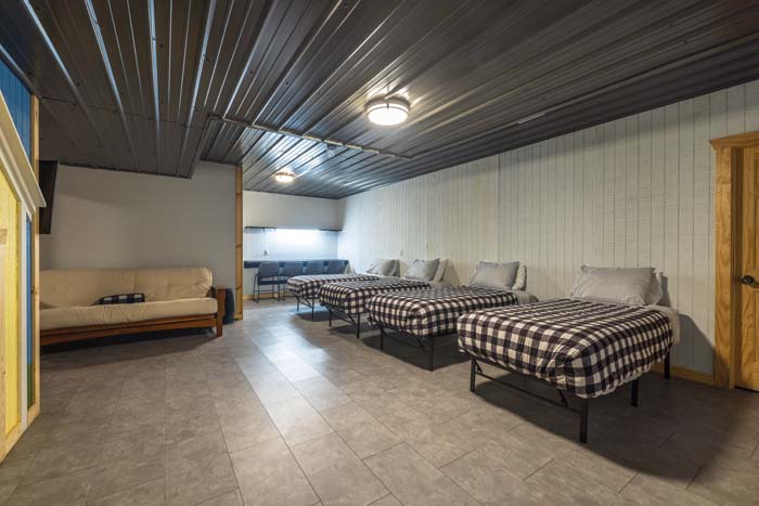 Lower-level bedroom with multiple beds and a futon