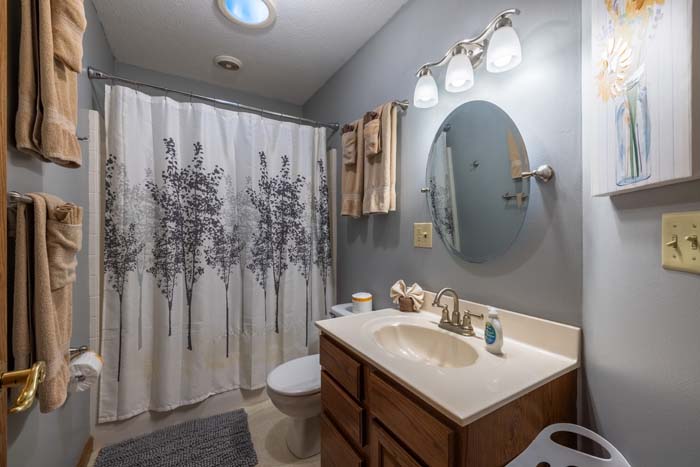 Bathroom vanity with framed mirror and shower at Peach Tree Lodge
