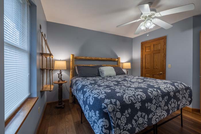 King bedroom with patterned bedding and natural light