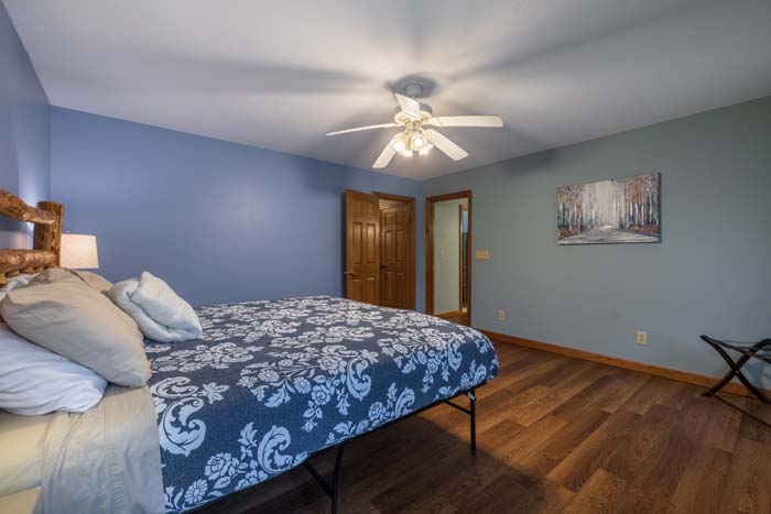 King bedroom with patterned bedding and deck access