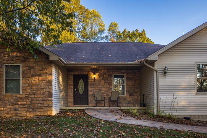 Covered front porch entry with stone accents and seating at Peach Tree Lodge