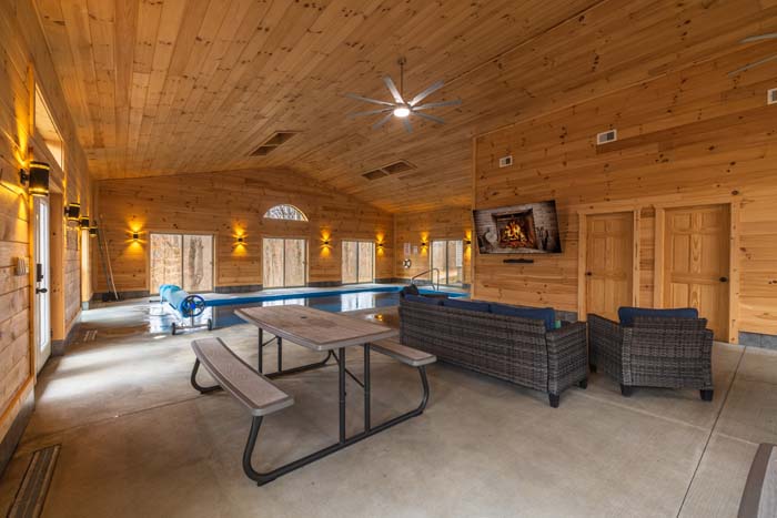Indoor pool house with lounge seating and TV at Peach Tree Lodge