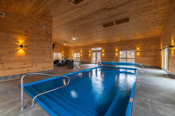 Heated indoor pool with wood paneling and wall sconces