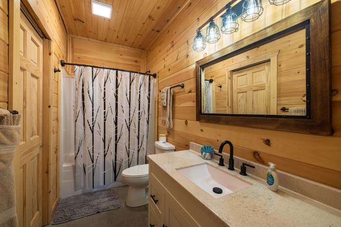 Wood-paneled bathroom with vanity and shower