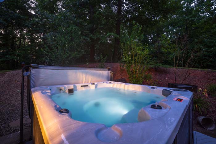 Hot tub at twilight surrounded by woods at Peach Tree Lodge