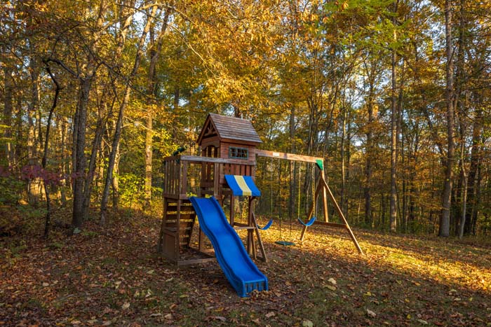 Wooden playground with slide and swings at Peach Tree Lodge